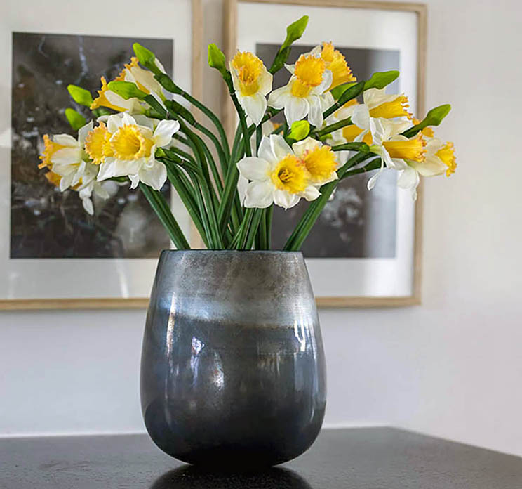 Påskelilje kunstig blomst af plast i hvid og gul vist i glasvase som en stor buket