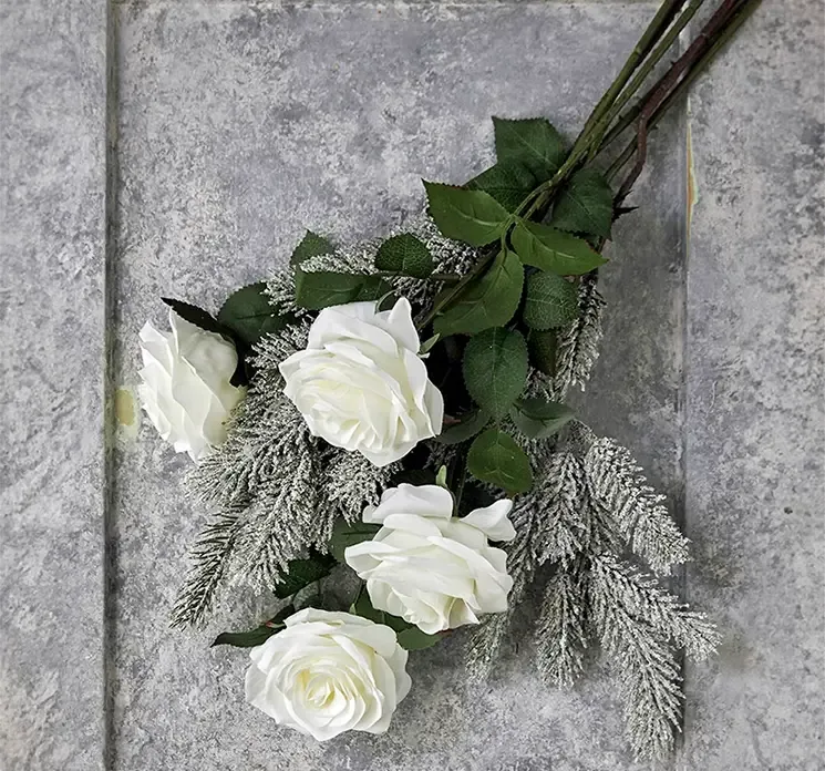 Rose Dijon i hvid af plast kunstig blomst vist sammen med kunstige grangrene med sne