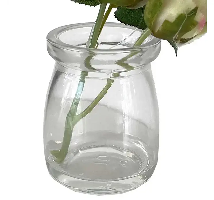 Rose kunstig blomst i creme farvet sat i lille glasvase closeup