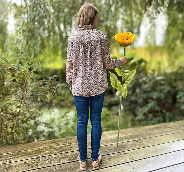 Solsikke kunstig blomst af plast i gul XL størrelse vist ved siden af menneske i havemiljø