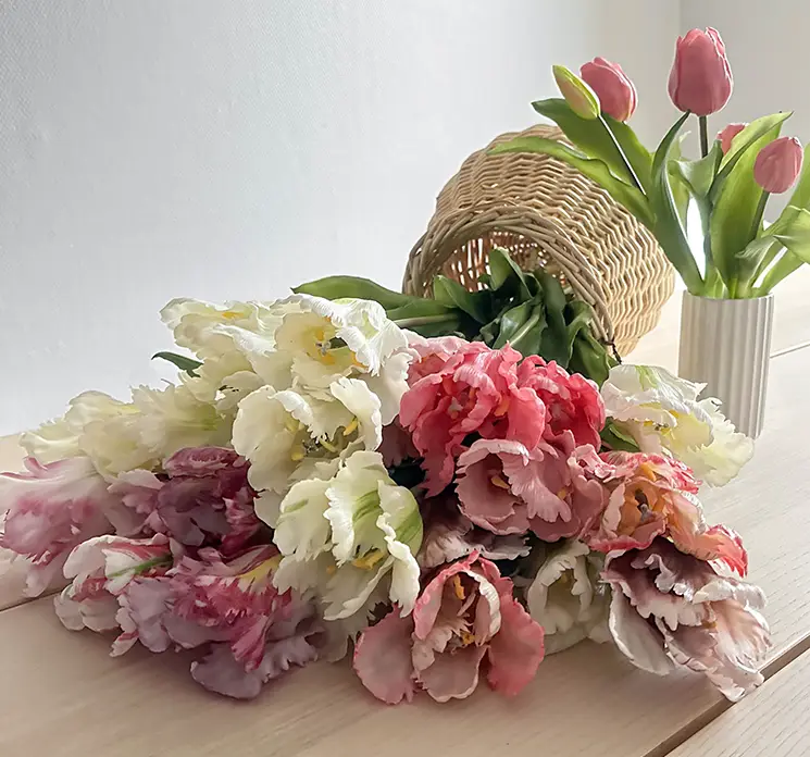 Tulipan buketter af kunstige blomster real touch af plast gummi vist liggende på bord med vase kande af flet