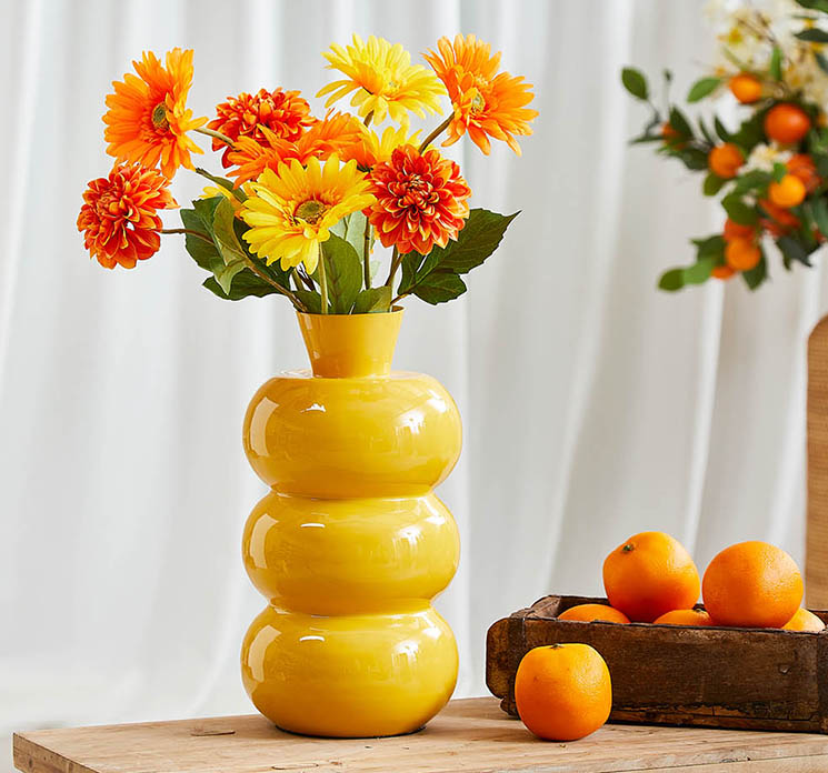 Gerbera kunstig blomst i gul vist i gul metal vase med andre blomster