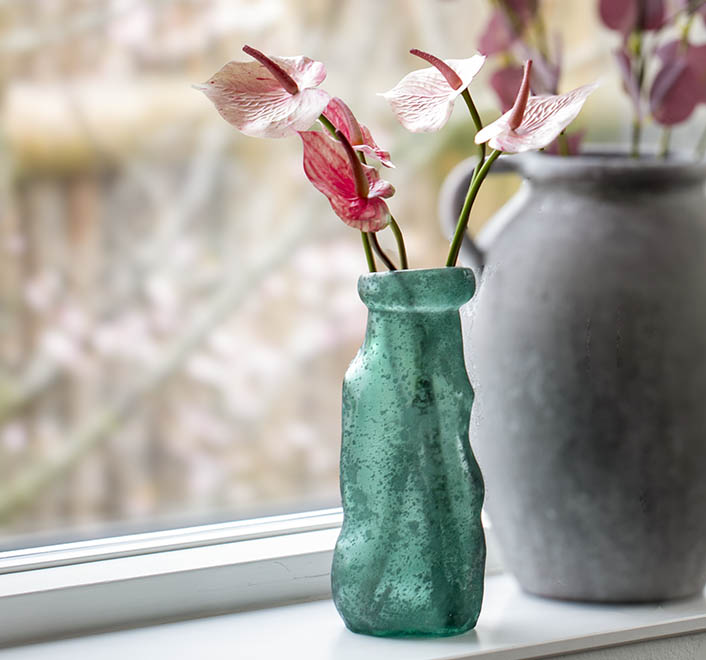 Flamingo kunstige blomster vist i simplicity frostet glasvase i grøen i vindueskarm
