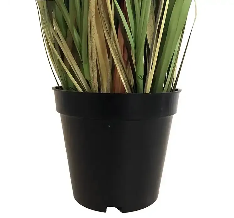 Kunstig fjergræs i sort potte af plast closeup af potte