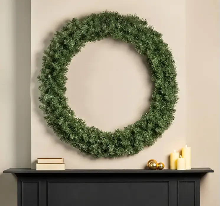 Kunstig Imperial gran krans af plast i grøn vist på væg over kamin