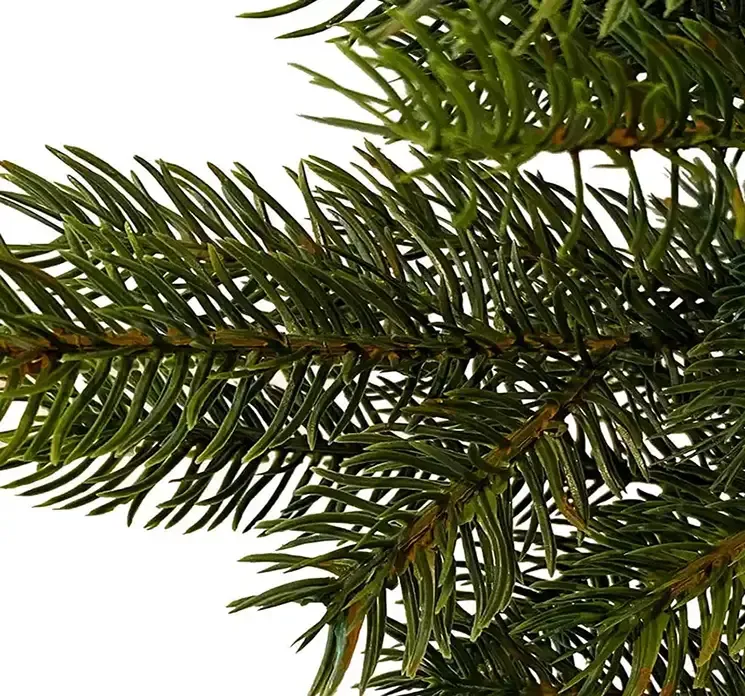 Kunstig gran juletræ grandis af plast i grøn med sort potte closeup