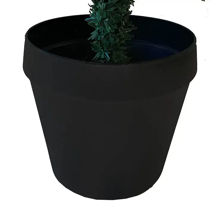 Kunstig gran juletræ grandis af plast i grøn med sort potte closeup af potte