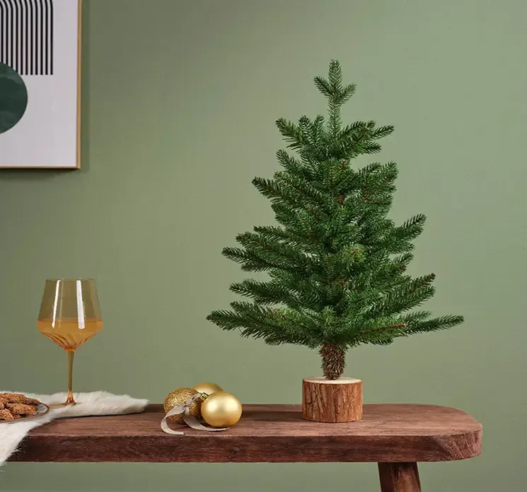 Kunstig gran juletræ greenhill af plast i grøn vist i miljø på en bænk