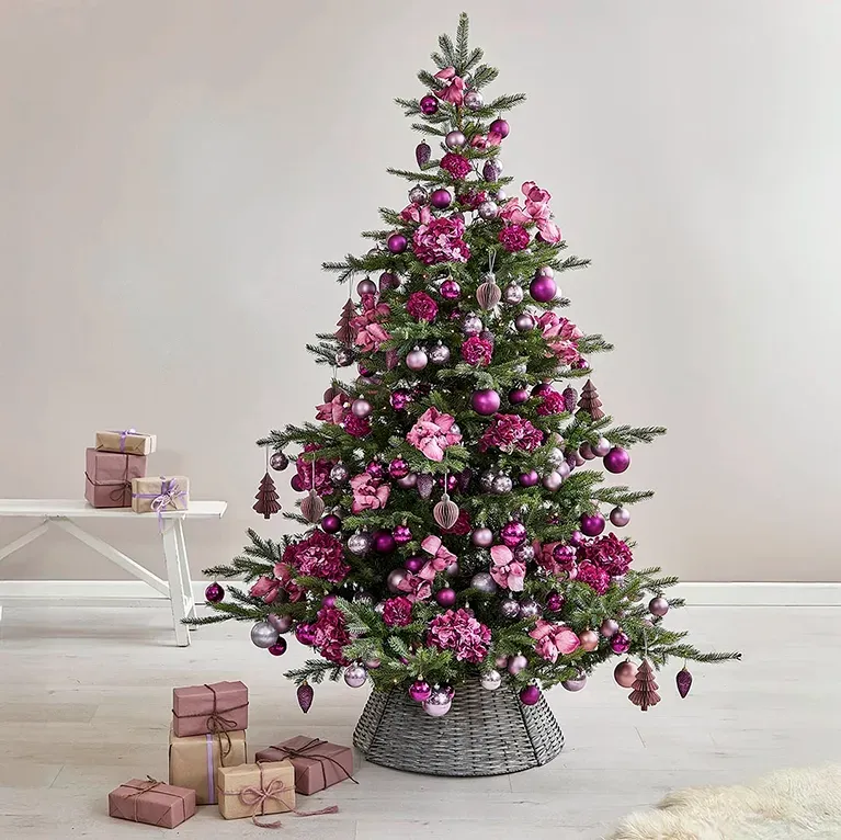 Kunstig grantræ grandis, men julekugler i lilla og kunstige blomster