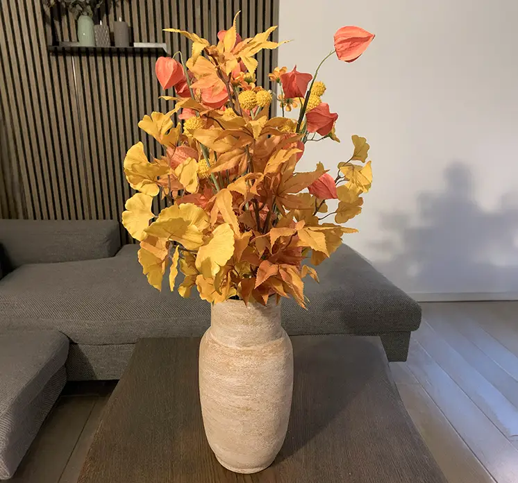 Gingko kunstig gren sat sammen med anananskirsebærgrene og en efterårsgren til en skøn buket i vase på stuebord