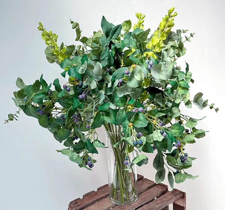 Blåbærgren kunstig med grønne blade af plast 75cm vist i vase med irlandsklokke og grønne grene