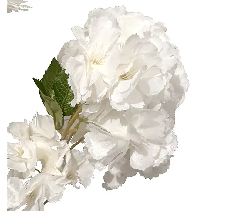 Kirsebærgren med fyldige kunstige blomster af plast i hvide closeup