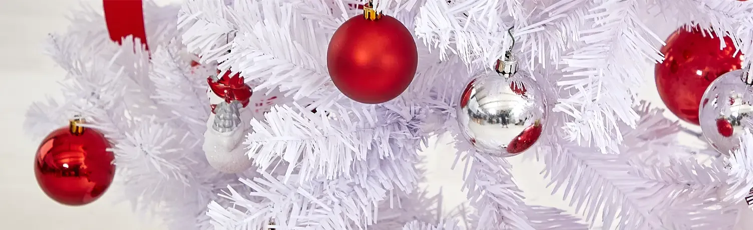 kunstig hvidt juletræ pyntet med røde og sølvfarvede julekugler