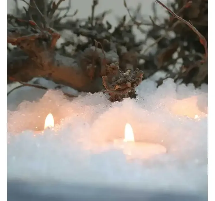 Kunstig instant snepulver giver et vådt look når det blandes med vand vist i miljø med fyrfadslys