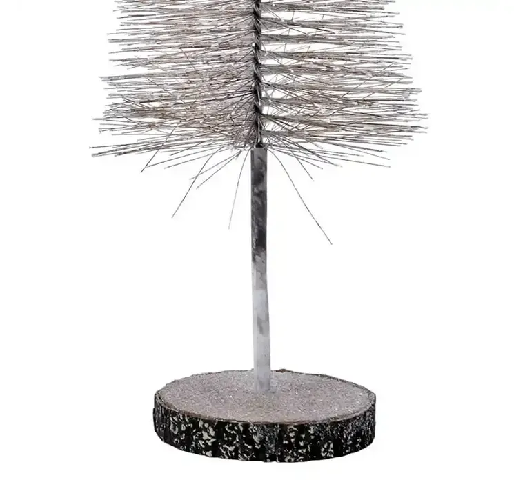 Kunstig børste juletræ af plast i brun på rund træfod closeup