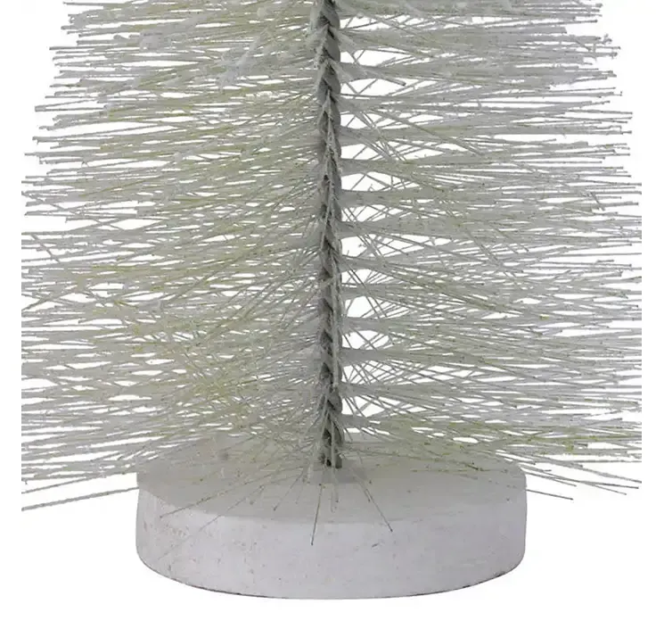 Kunstig børste juletræ af plast i grøn på rund hvid fod closeup