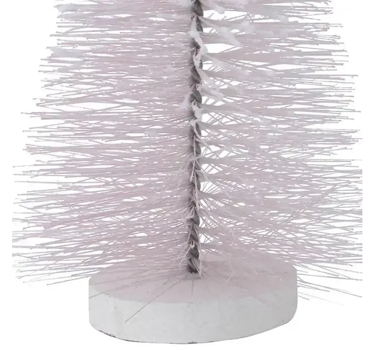 Kunstig børste juletræ af plast i lyserød på rund fod i hvid closeup