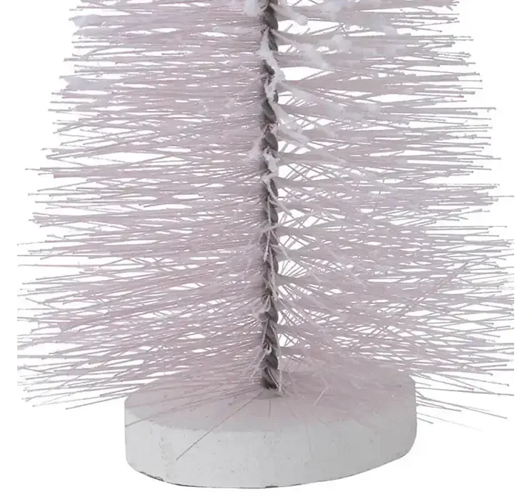 Kunstig børste juletræ med sne af plast i lyserød på rund fod closeup