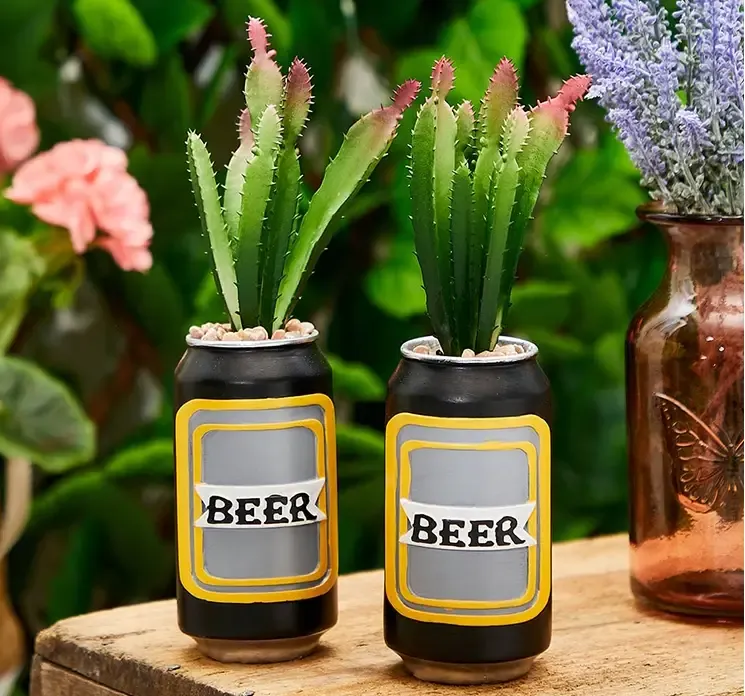 Kunstig kaktus i dåse vist i miljø på bord med to ved siden af hinanden