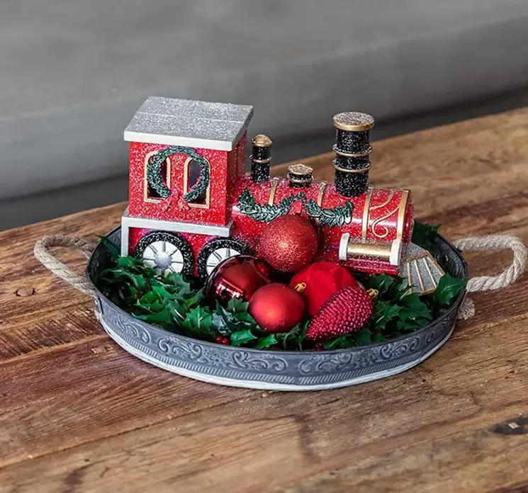 Juletog lokomotiv i plast i rød vist i juledekoration på stuebord