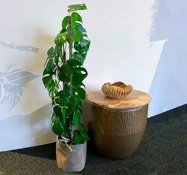 Potteskjuler af læder vist med kunstig plante i miljø
