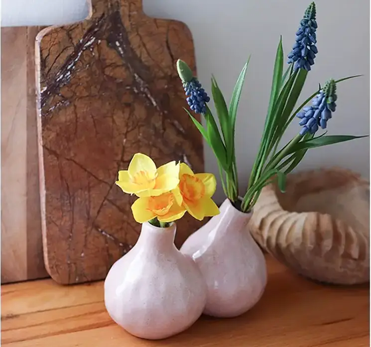 Perlehyacint buket af kunstige blomster i blå af plast vist i lille porcelænsvase med to huller i køkkenmiljø