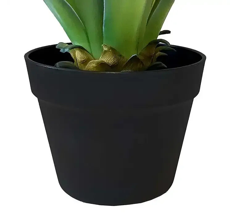 Kunstig agave plante i sort potte af plast closeup af potte