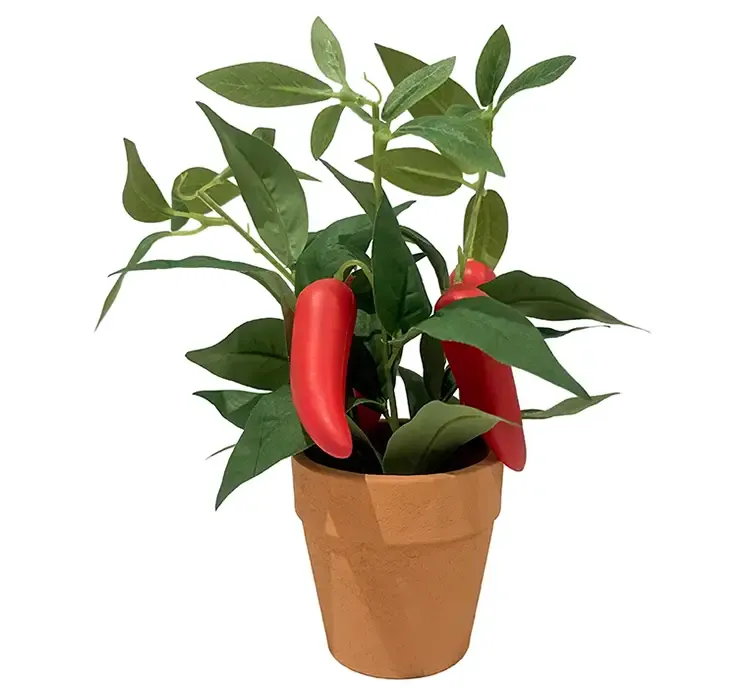 Kunstig chiliplante med røde chilipeber i potte af plast