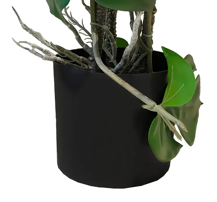 Kunstig monstera plante opbundet i potte af plast closeup af potte