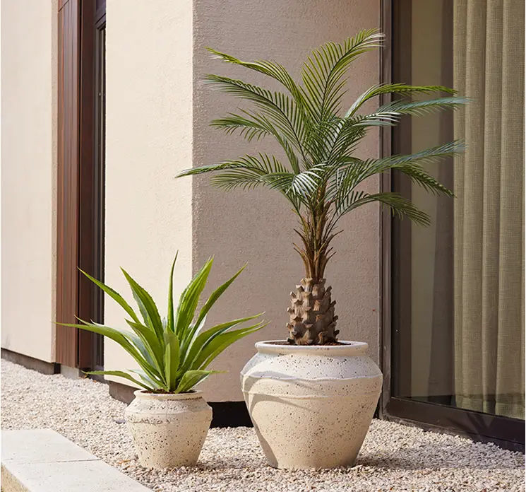 Palme og agave kunstige uv-beskyttede planter vist i krukker på terrasse