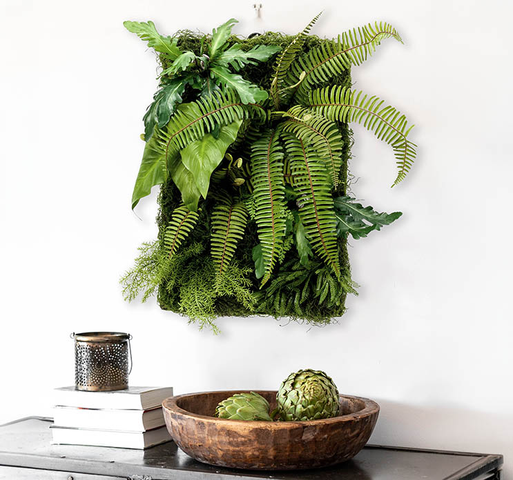 Kunstig plantevæg på plade med mos og planter i grøn vist i stuemiljø