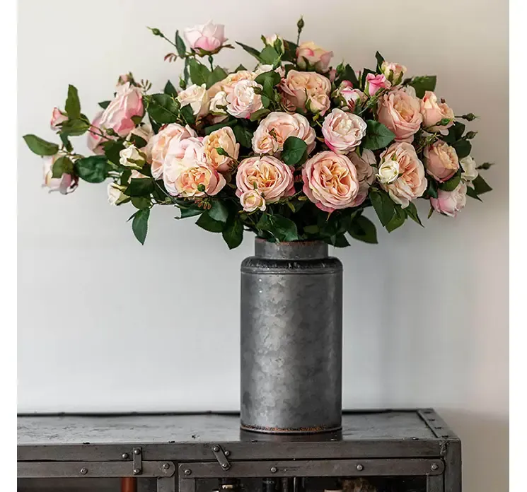 Kunstig rosenkvist af kunstsilke i fersken farvet vist i vase i miljø