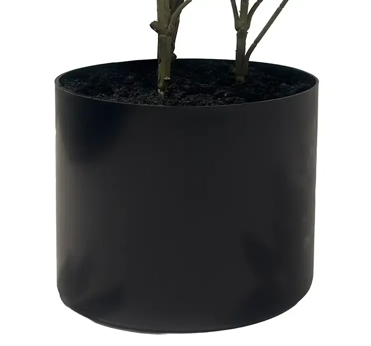 Kunstig aralia træ i sort potte closeup af potte