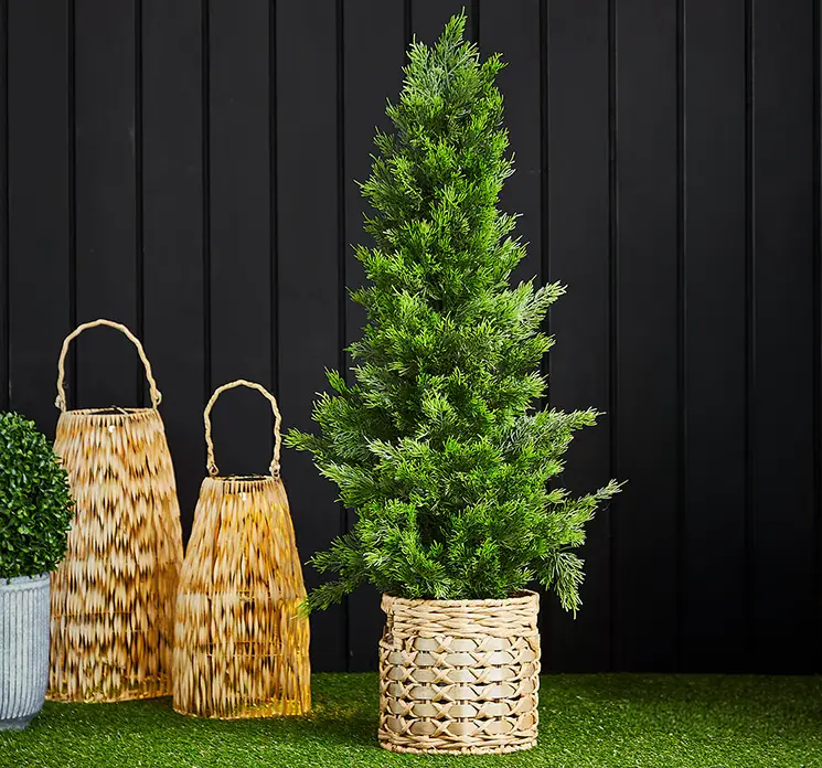 Cypress kunstig træ i grøn af plast uv-beskyttet i sort potte 90cm vist i havemiljø