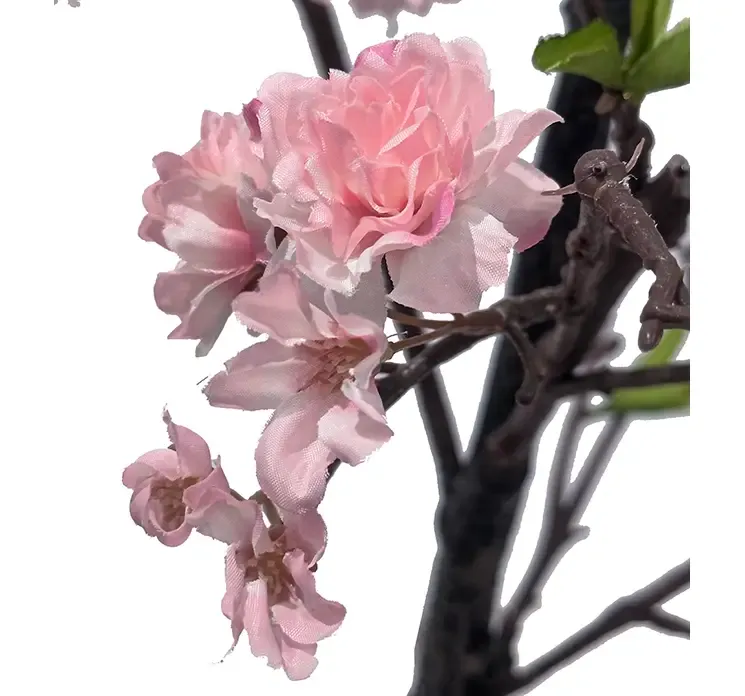 Kunstig kirsebærtræ med lyserøde blomster i sort potte af plast closeup af blomster