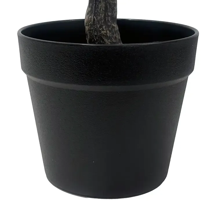 Kunstig kirsebærtræ med lyserøde blomster i sort potte af plast closeup af potte