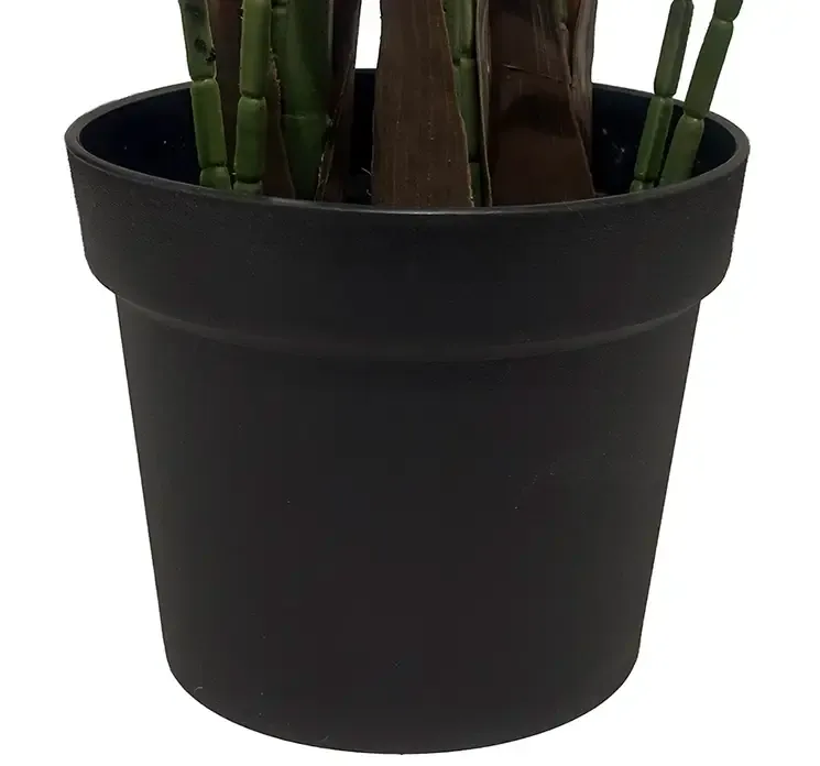 Kunstig palmetræ i sort potte af plast closeup af potte