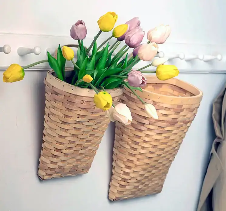 Kurve flettet af bambus i naturfarvet med hanke til ophæng her vist med kunstige tulipan buketter