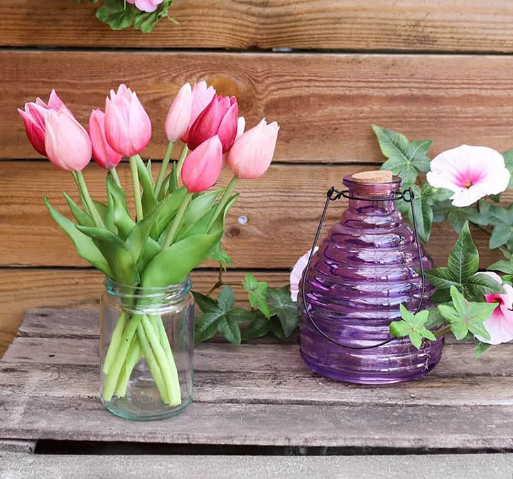 naturtro tulipaner i lyserød sat sammen med en fin lilla hvepsefanger i glas med korkprop