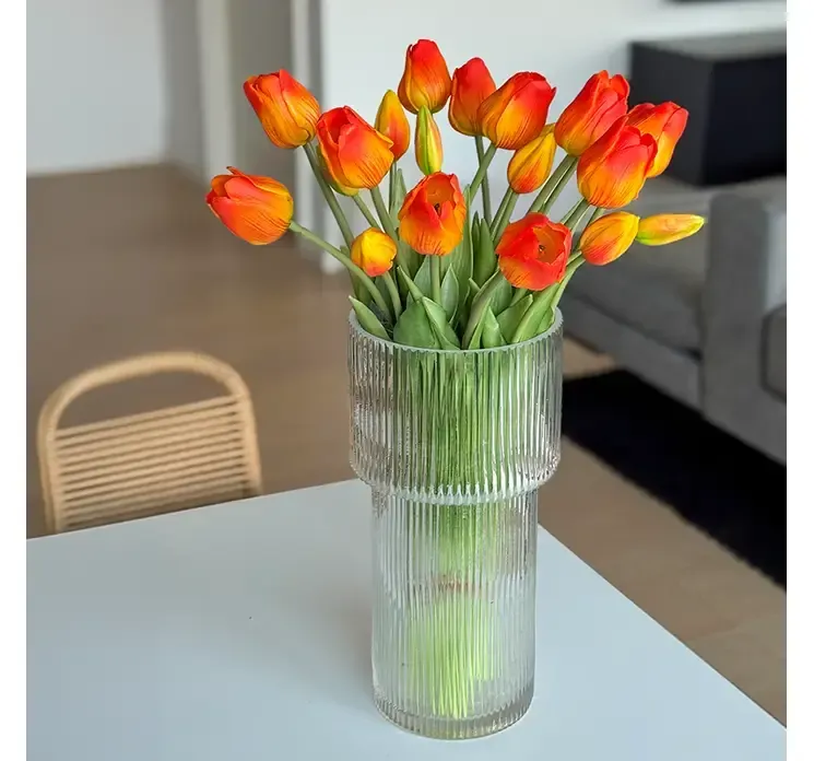 Kunstig tulipan buket i orange nuancer af gummi og plast vist på spisebord i miljø