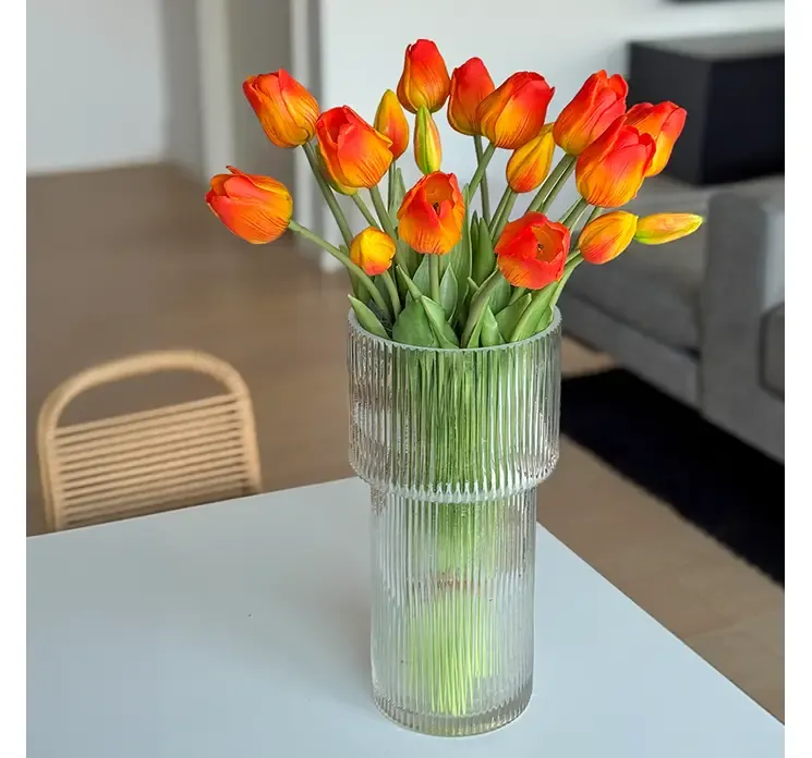 Kunstig tulipan buket i orange nuancer af gummi og plast vist på spisebord i miljø