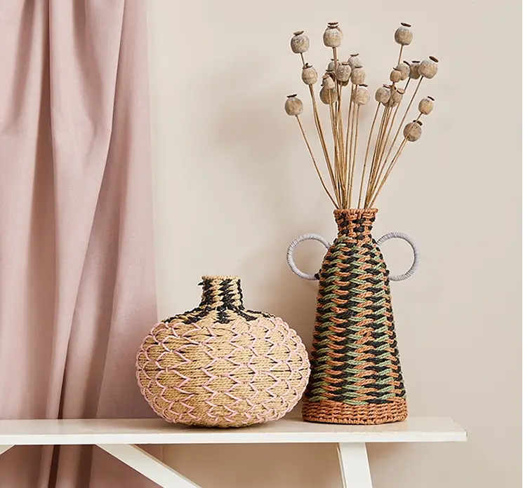 Valmuefrøkapsler tørret i beige vist i stuemiljø i flettet vase