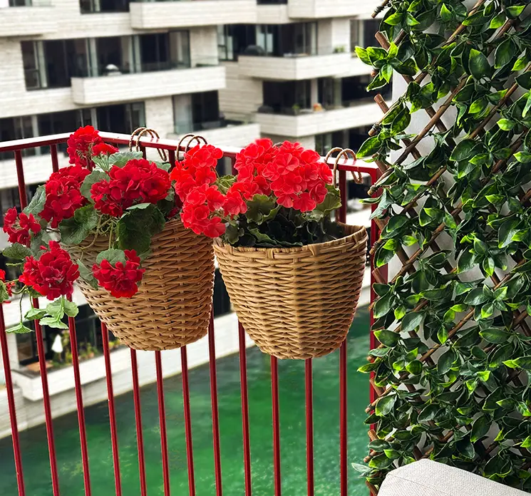 Kurve med ophæng af rattan i brun 2 stk vist med kunstige pelargonier på altan