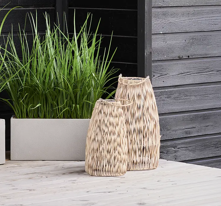 Lanterner af rattan med solcelle belysning vist på terrasse