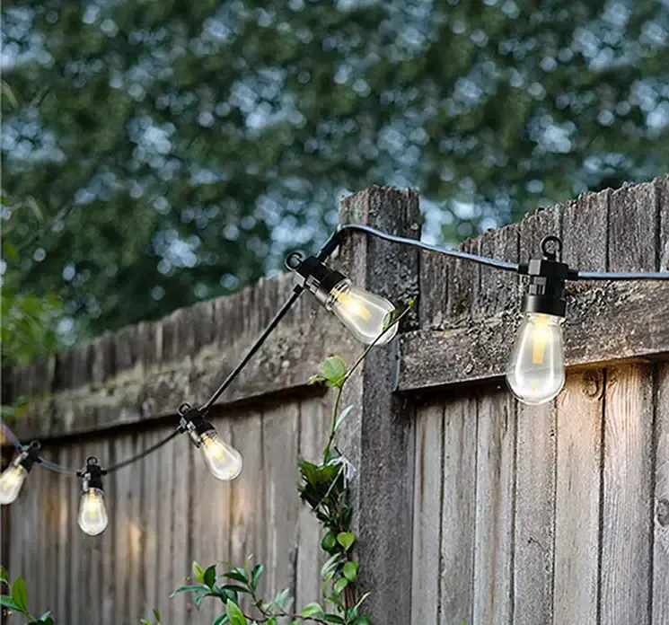 Led lyskæde med aflange pærer til inden og udendørs brug vist i have