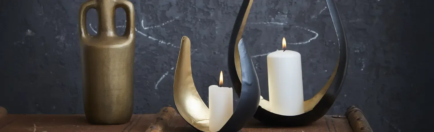 Flotte skulpturelle lysestager i metal i guld og sort farvet