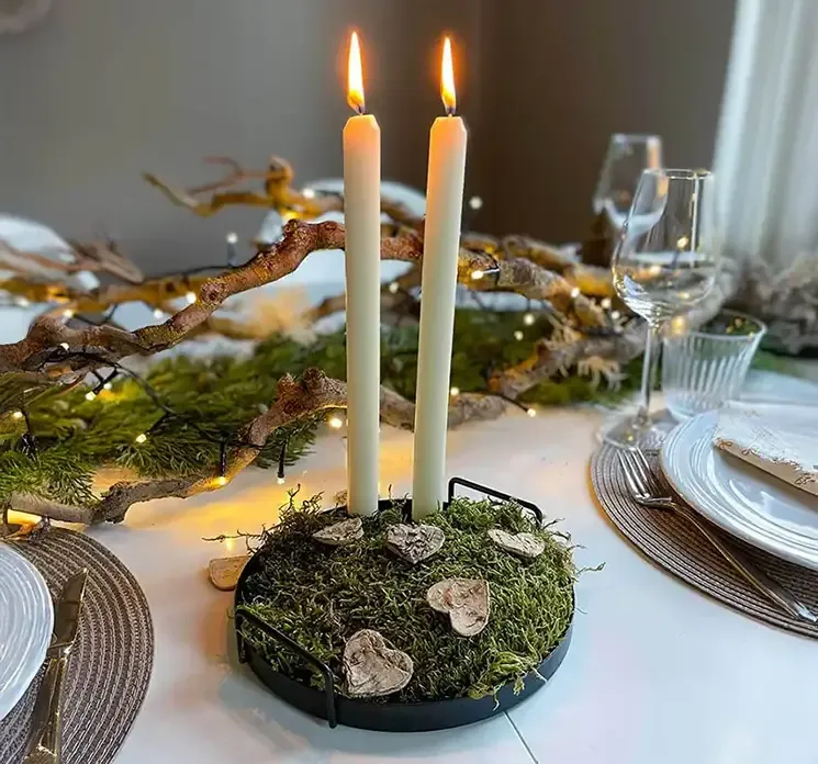 Hjerter i bark natur farvet vist på julebord i en juledekoration med mos og lys