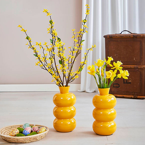 Kunstige påskeliljer og forsythiagrene i stuemiljø