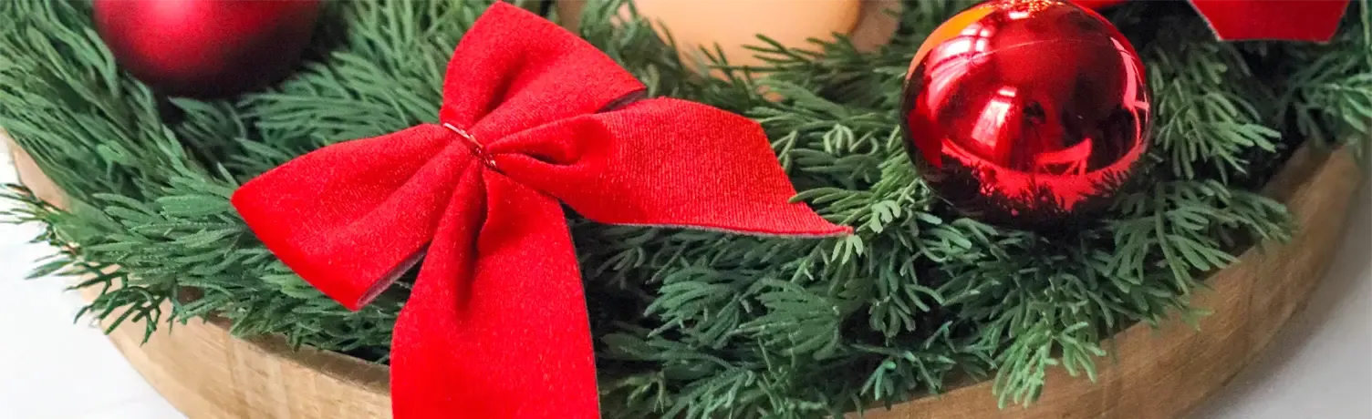 Lille fin sløjfe sat i en juledekoration med kunstig gran