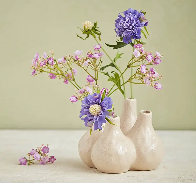 Brudeslør og skabiosa kunstige blomster af plast sat i porcelænsvase med fire huller til blomster